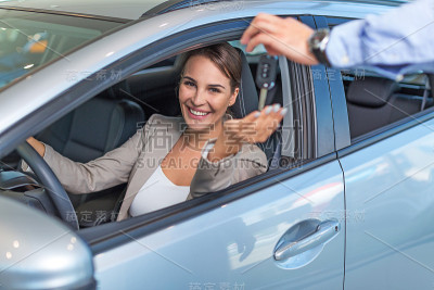 快乐的年轻女人，开着新车