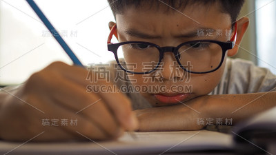 一个亚洲男孩在做作业。