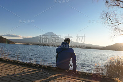 日本——一个男人坐在川口湖边看着富士山