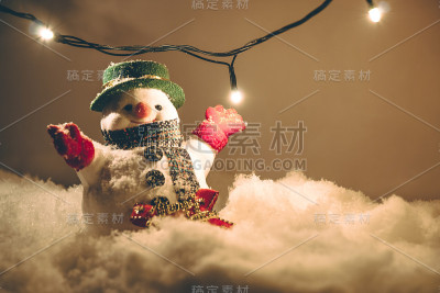 雪人和灯泡站在一堆雪中