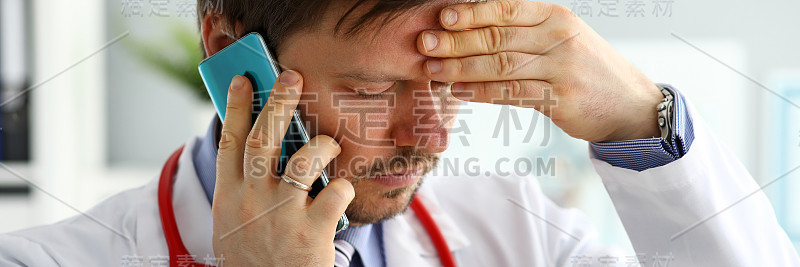 焦虑的医生通过电话听病人的抱怨。