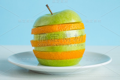 把几片苹果和桔子放在一个白盘子里