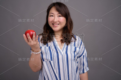 工作室拍摄的成熟美丽的亚洲女商人在灰色的背景
