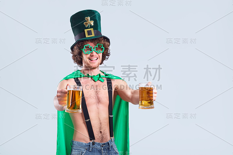 一个年轻的卷发男人，穿着圣帕特里克的西装，戴着马克杯