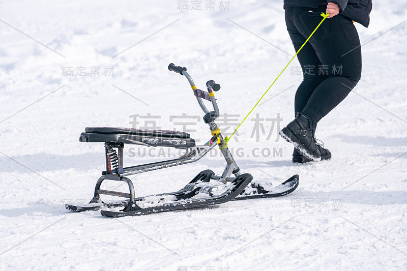 孩子在拉雪橇和跑上雪坡的后视图