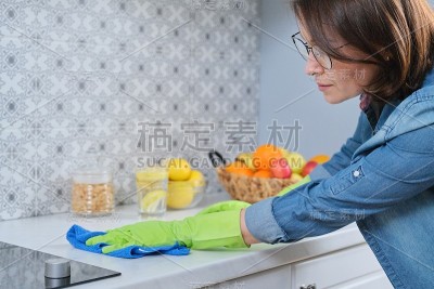 戴手套的女人用抹布擦拭厨房台面