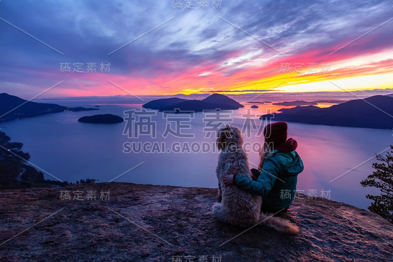 爱冒险的女孩带着狗在山顶徒步旅行