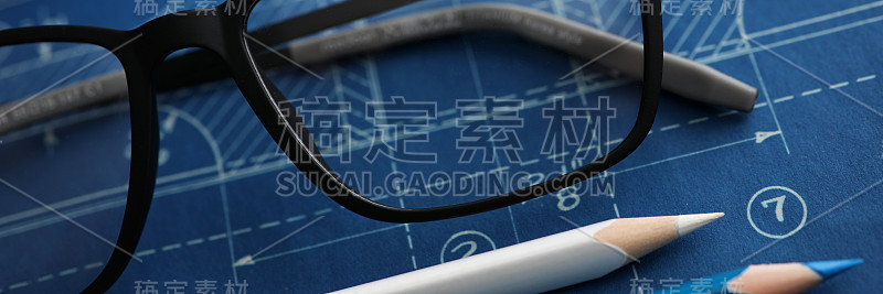 图纸放在工作台上，上面有绘图工具