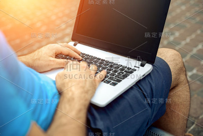 特写英俊男子的手触摸笔记本电脑的屏幕