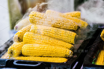桌上有热玉米种子和熟玉米芯在钢板上