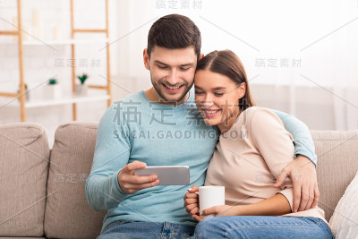坐在沙发上拥抱手机的夫妻