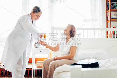 照顾老人。医生在家探望老年病人。