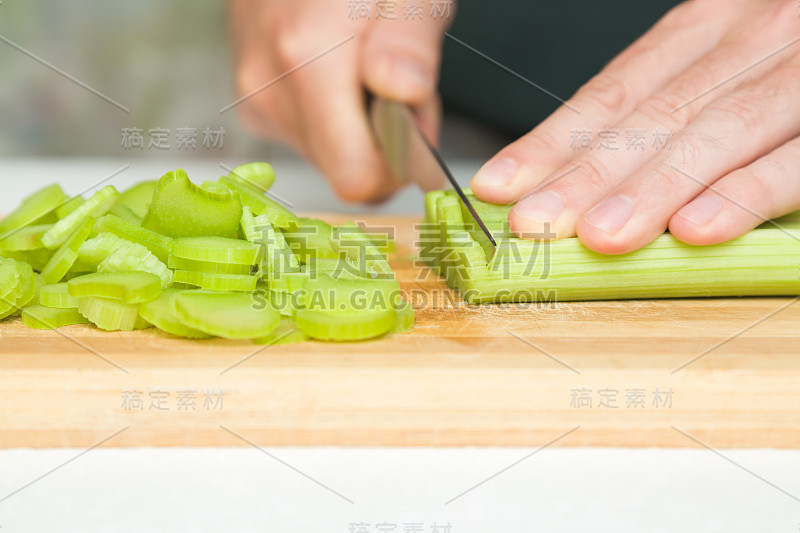 厨师用刀将大黄切在木板上。准备做饭。