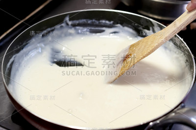 调味酱。用木铲在平底锅里搅拌奶油酱汁