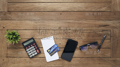 计算器，记事本，罐子，玻璃杯，笔和写字板放在木桌上