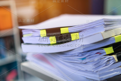 堆放未完成的文件报告文件，在大学教师办公桌上堆放商业文件和加班文件，在工作场所凌乱的纸书评估法律文件
