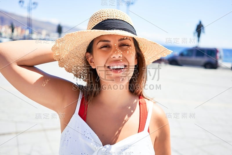 在一个阳光明媚的夏天，年轻美丽的女人快乐地走在城市的街道上