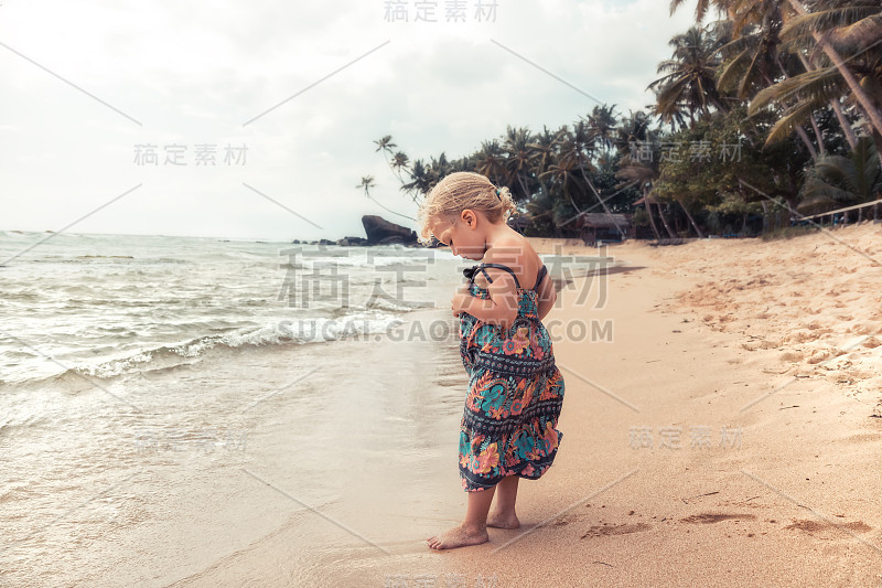 美丽的孩子女孩走在海滩上在暑假的概念，无忧无虑的童年旅行生活方式