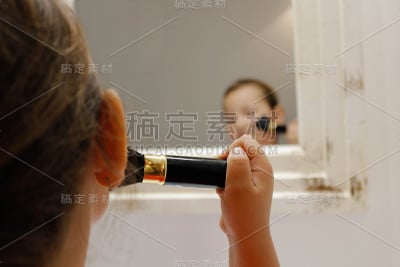 女孩对着镜子抹着腮红