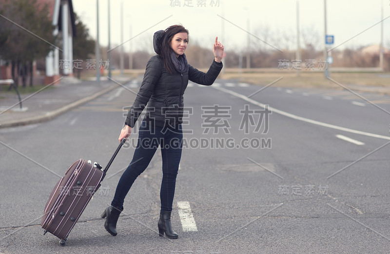 一名白人女性举起手臂叫出租车