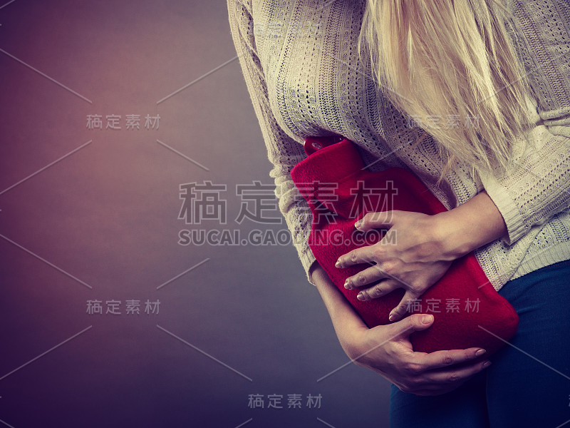 女人拿着热水瓶感觉胃痉挛