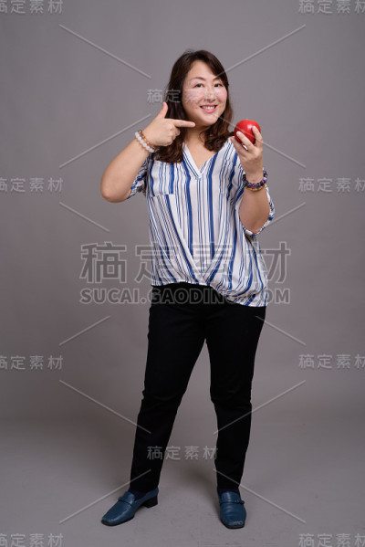 工作室拍摄的成熟美丽的亚洲女商人在灰色的背景