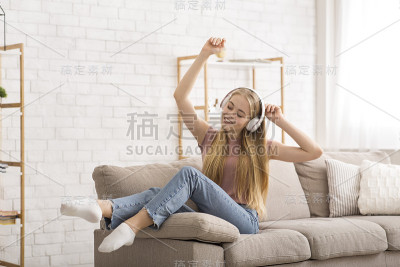 快乐的女孩在家听音乐跳舞