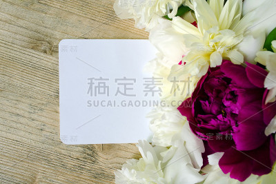 花，牡丹，白色和淡紫色的颜色与一张便条在木桌上。模拟贺卡