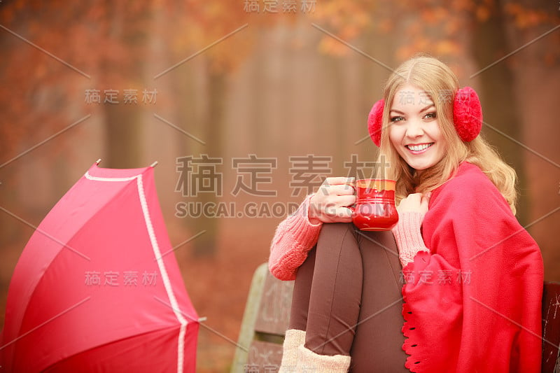 女孩在秋天的公园享受热饮