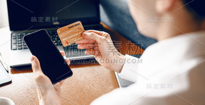 上面是一个白人商人用银行卡和手机买东西的画面