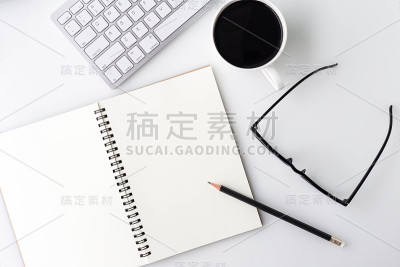 现代白色办公台面，桌上有笔记本电脑、笔记本电脑等用品。顶部视图与复制空间上的白色背景。俯视图，平放。