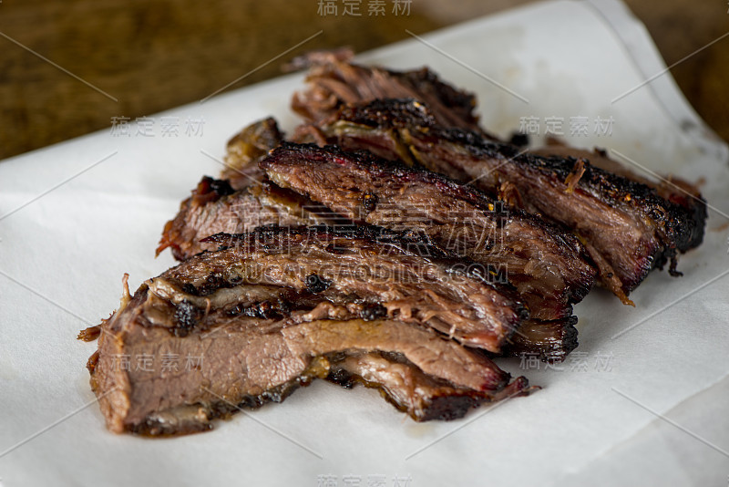 牛胸肉烧烤传统德州烟熏屋。揉搓香料和慢烟在一个经典的德克萨斯州烟屋在牧豆木屑在传统的经典烧烤方法。胸