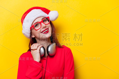 戴着圣诞老人帽戴着耳机的女人
