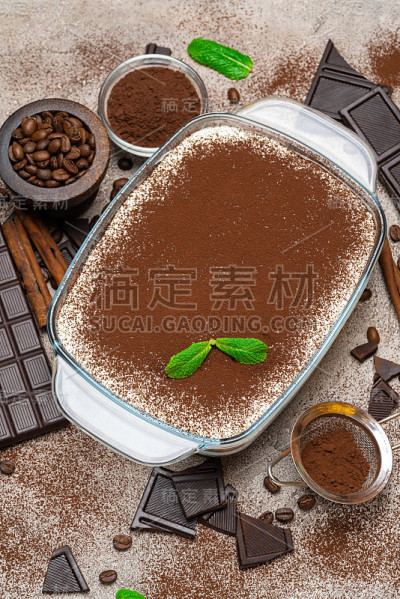 传统的意大利提拉米苏甜点在玻璃烤盘在混凝土背景