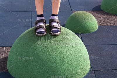 儿童的脚在操场上的平衡设备