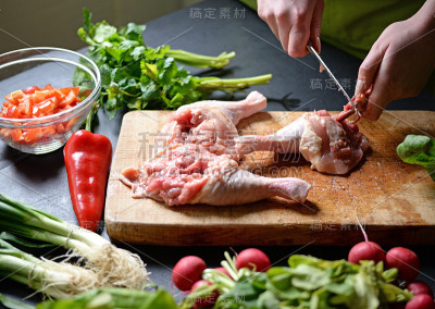 年轻女子准备用蔬菜做鸡肉