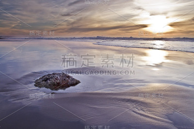 海滩日落与反射湿沙