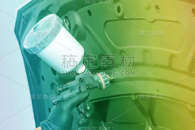 油漆汽车零件，一个男人用喷枪，修理汽车车身