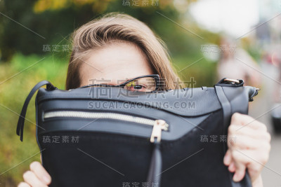 顽皮的女人拿着钱包凑近她的脸