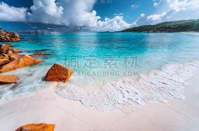 塞舌尔，拉迪戈，Grand Anse海滩上轻柔的泡沫浪。白云朵朵，海洋晶莹剔透的度假度假景象