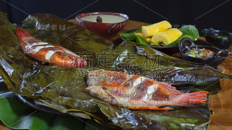 菜肴有鱼麦托斯，厄瓜多尔亚马逊的典型食物，搭配木薯，熟香蕉和沙拉在一个乡村木桌上