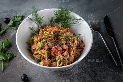 白色盘子上撒有芝麻的蔬菜、橄榄和虾的侧视图沙拉，灰色背景是乡村风格，带有复制空间