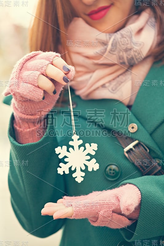 手持雪花装饰的年轻女性