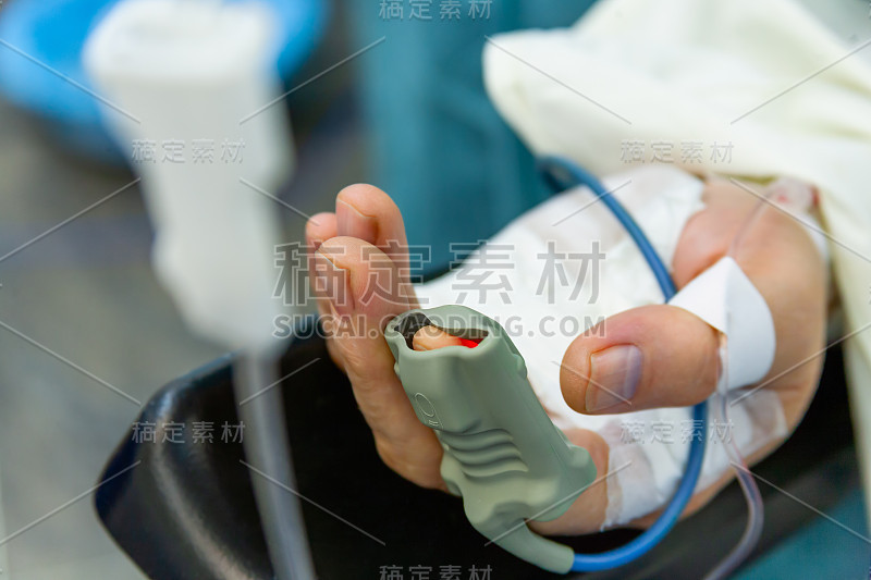 Patientâ’s Hand with Pulse oxygen meter on Finge