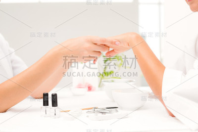 水疗美容院为女性客户做指甲的美容师