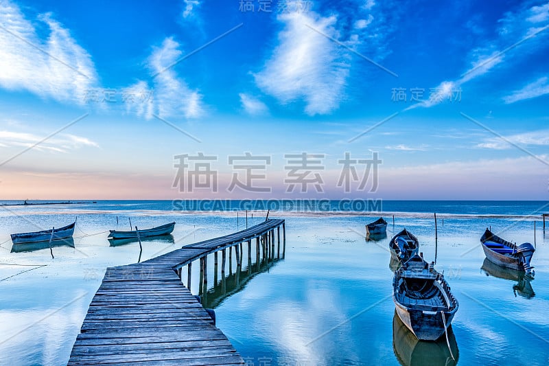 美丽的早晨风景，湖上的船只停泊在码头和木桥在日出