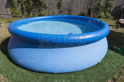 蓝色的橡胶池在草地上为孩子们。