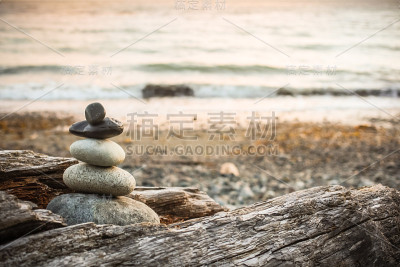 Inukshuk Cairn在海滩上的浮木上