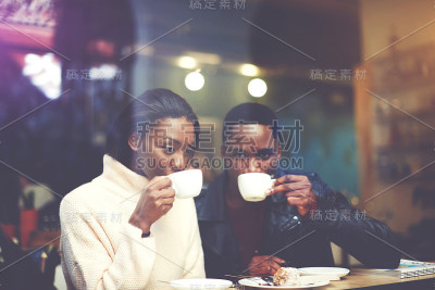 黑人男人和女人最好的朋友喝热卡布奇诺，同时在寒冷的冬天在户外散步后一起取暖，两个黑皮肤的人放松在咖啡