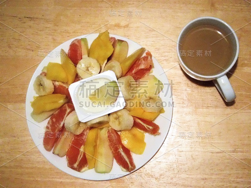 健康无谷蛋白早餐或零食-水果盘(柚子，苹果，芒果，香蕉)，酸奶和咖啡牛奶